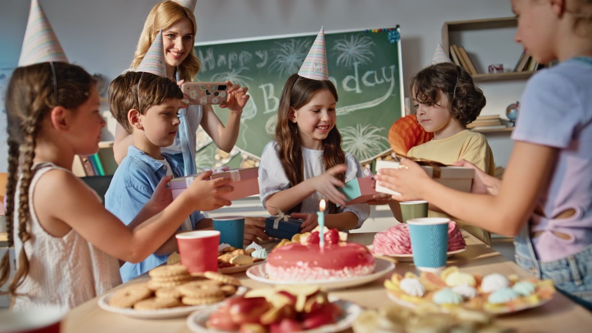 Kids celebrating birthday in classroom with gifts