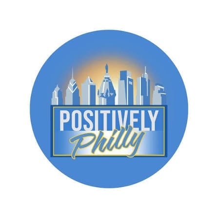 Positively Philly logo featuring Philadelphia skyline silhouette on blue circular background with gold text